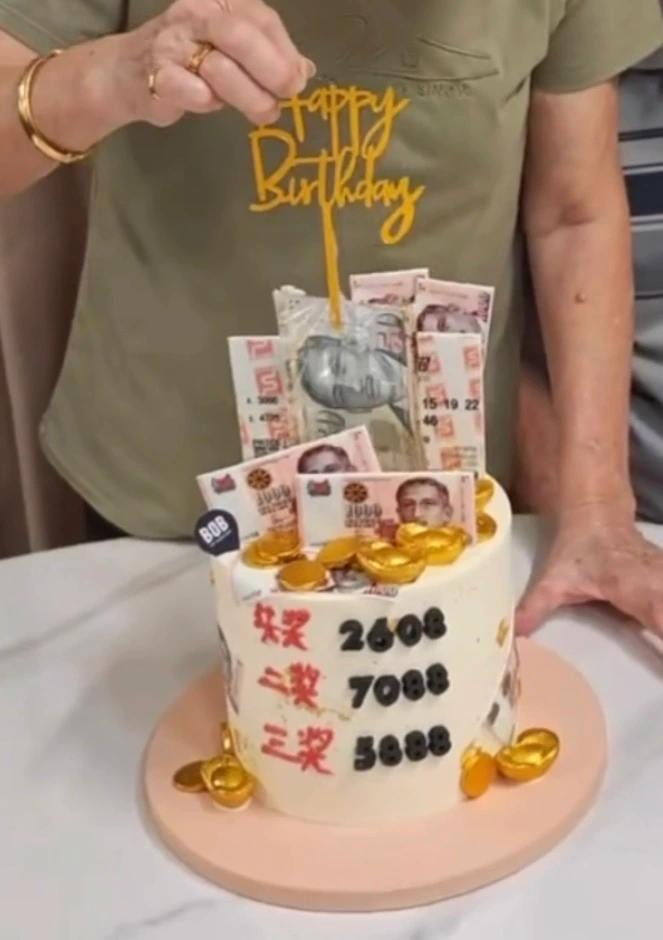 Money being pulled from customised TOTO Huat birthday cake in Singapore