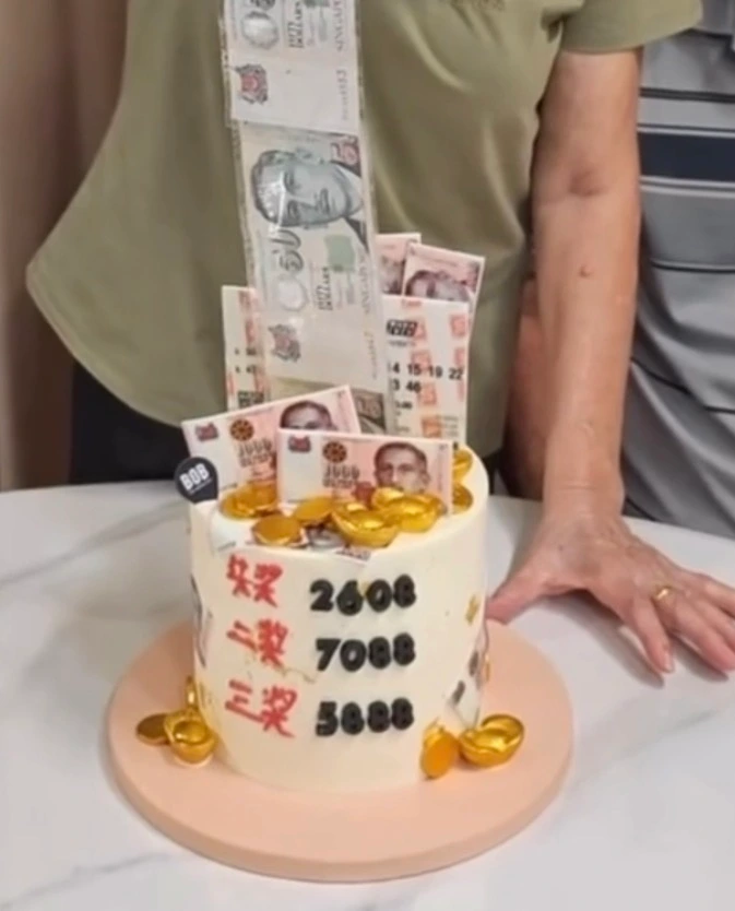 Custom TOTO-inspired money pulling Huat birthday cake with Singapore dollar notes by Bob the Baker Boy