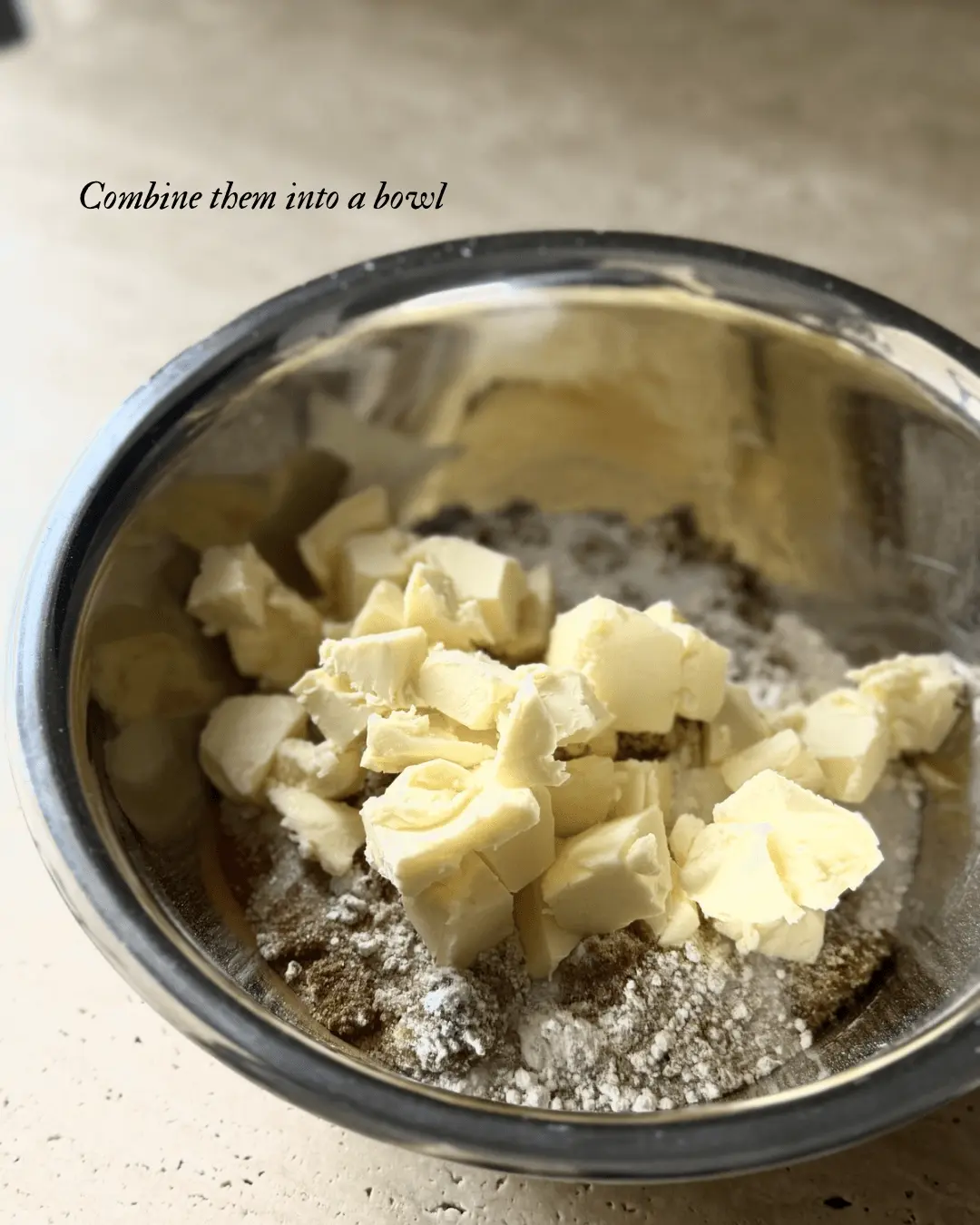 Cubed cold butter added to flour and sugar mixture for homemade berry crumble